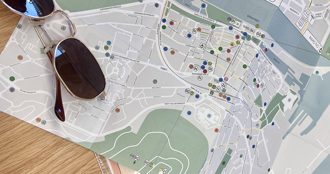 Travel planning with a city map and sunglasses, representing exploration and responsible travel